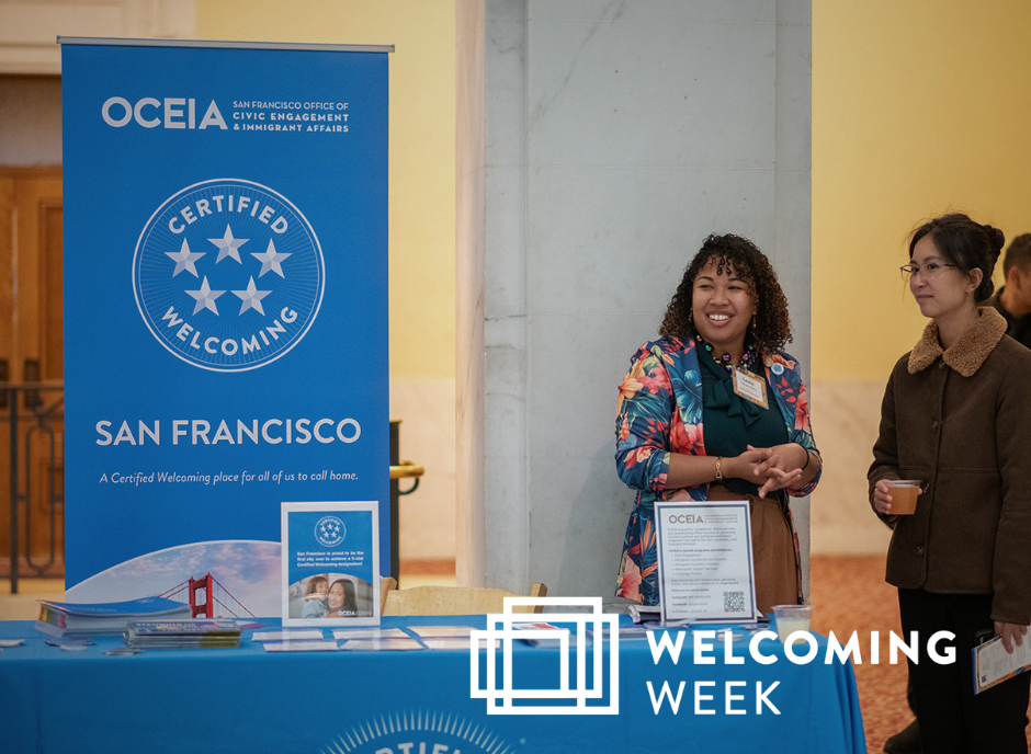 Two women talk near outreach table with a standing banner sign that shows San Francisco's 5 Star Certified Welcoming desingation