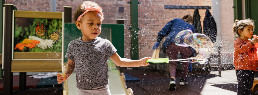 Child playing with bubbles on playground