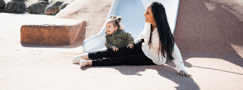 Mother and child playing on a slide in a park