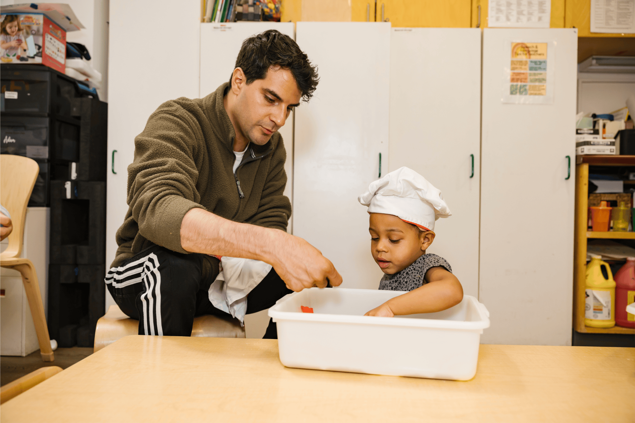 Early educator and child baking in ECE calssroom