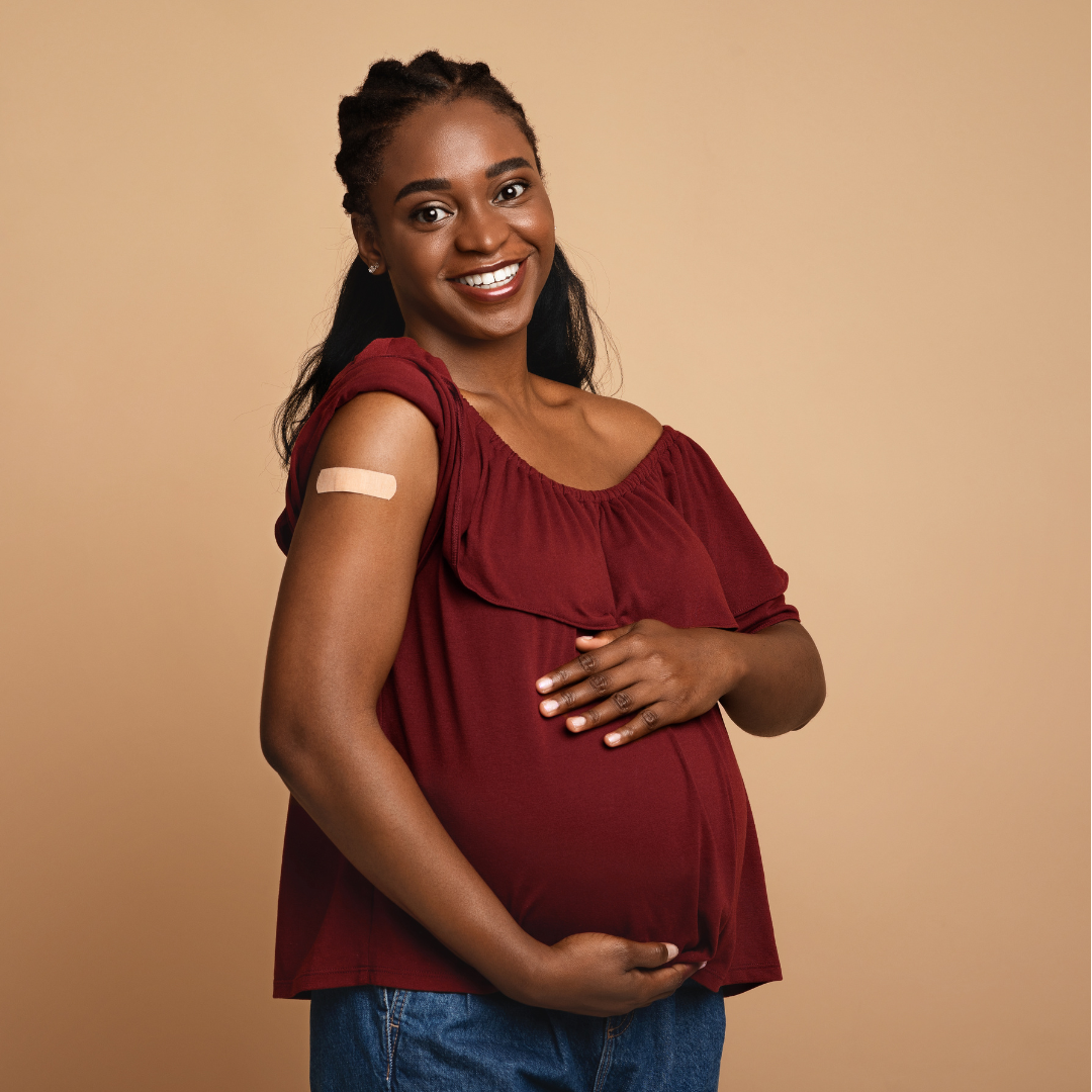 Pregnant woman with bandaid on shoulder