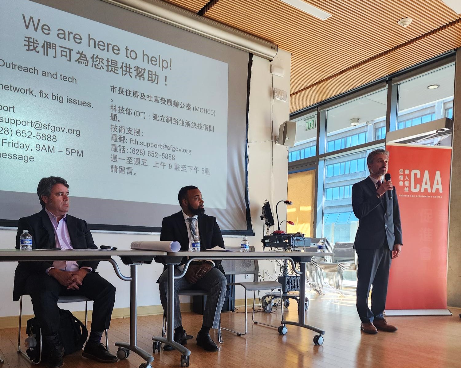 Panel at a Chinatown digital access workshop with translated information on free in-home internet.