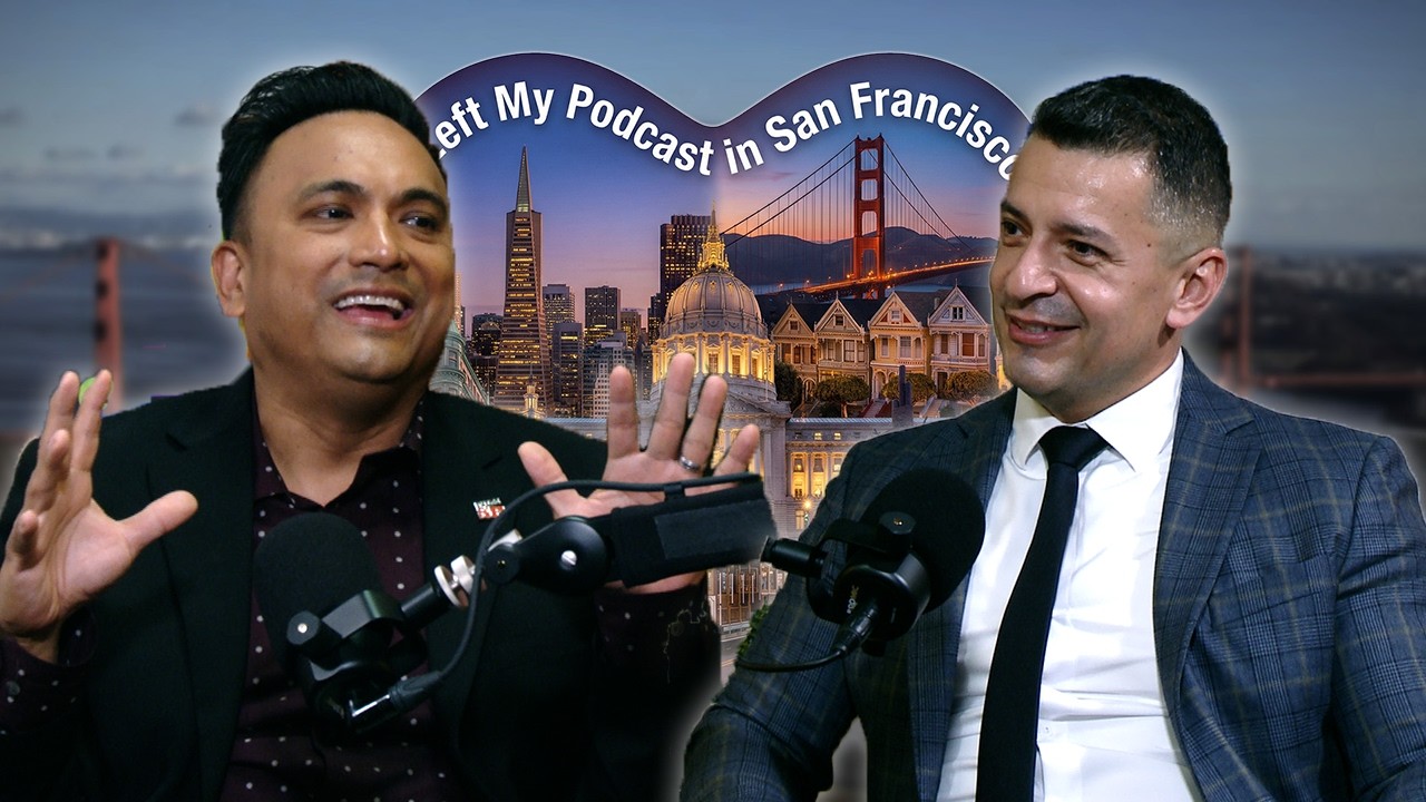 Two men in suits converse on a podcast