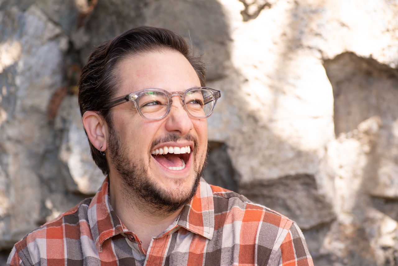 Caucasian trans man with a joyful expression